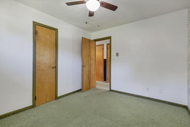 unfurnished bedroom featuring light colored carpet, baseboards, and ceiling fan