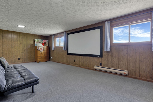 home theater room featuring carpet floors, a textured ceiling, baseboards, and a baseboard heating unit