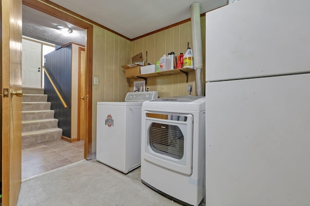 laundry room with separate washer and dryer, laundry area, wood walls, and ornamental molding