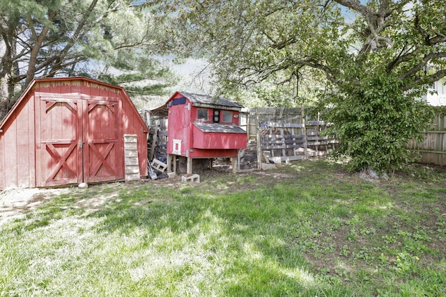 view of yard featuring fence, exterior structure, an outbuilding, and a storage unit
