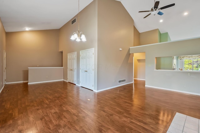 unfurnished living room with high vaulted ceiling, visible vents, baseboards, and ceiling fan with notable chandelier