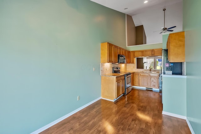 kitchen featuring decorative backsplash, black microwave, baseboards, high vaulted ceiling, and electric stove