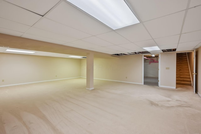 finished basement featuring carpet floors, stairs, baseboards, a drop ceiling, and visible vents