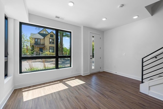 entryway with baseboards, stairs, wood finished floors, and visible vents