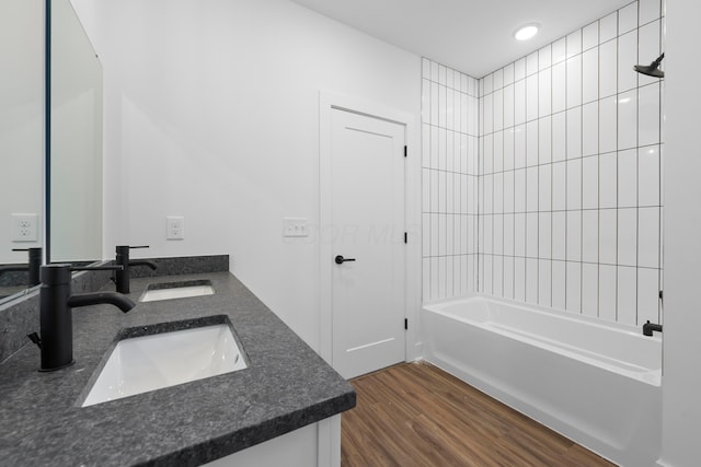 full bathroom featuring shower / bath combination, a sink, wood finished floors, and double vanity