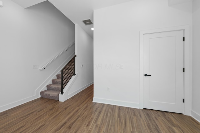 interior space featuring stairs, baseboards, visible vents, and wood finished floors