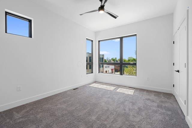 unfurnished bedroom featuring baseboards, visible vents, ceiling fan, and carpet