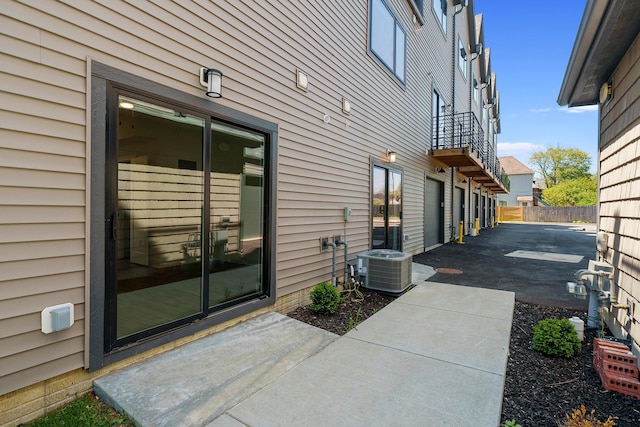 exterior space with central air condition unit, fence, and a patio area
