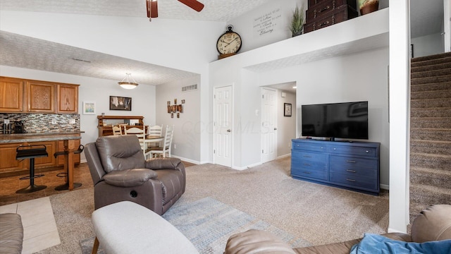 42 Ellington Commons Ln, Granville, OH 43023 - living area with ceiling fan, light colored carpet, a textured ceiling, stairs, and baseboards