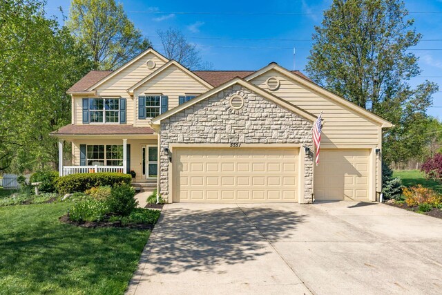 traditional-style house with concrete driveway, an attached garage, and stone siding
