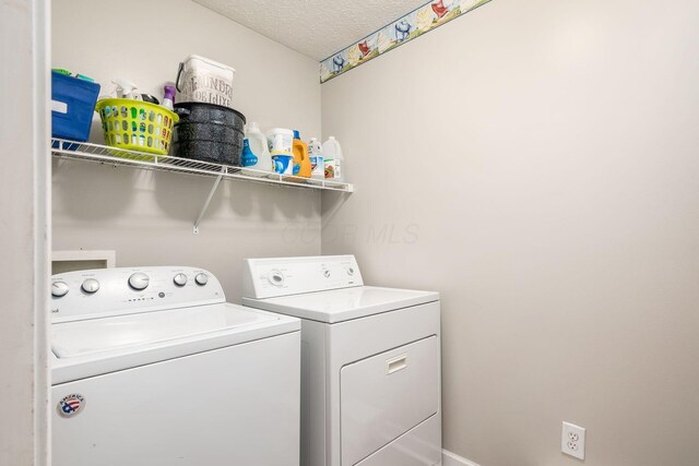 laundry room with independent washer and dryer, a textured ceiling, and laundry area