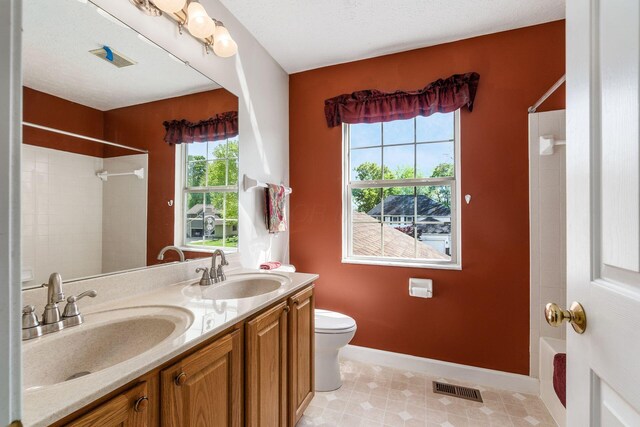 full bathroom featuring toilet, baseboards, visible vents, and a sink