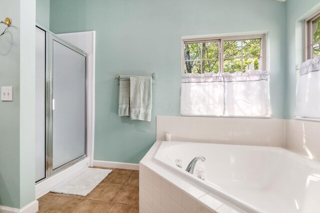 bathroom featuring baseboards, tile patterned flooring, a shower stall, and a bath