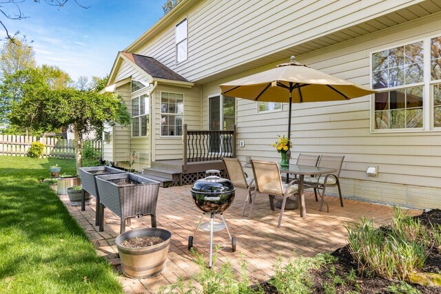 view of patio / terrace with fence, a wooden deck, and outdoor dining space