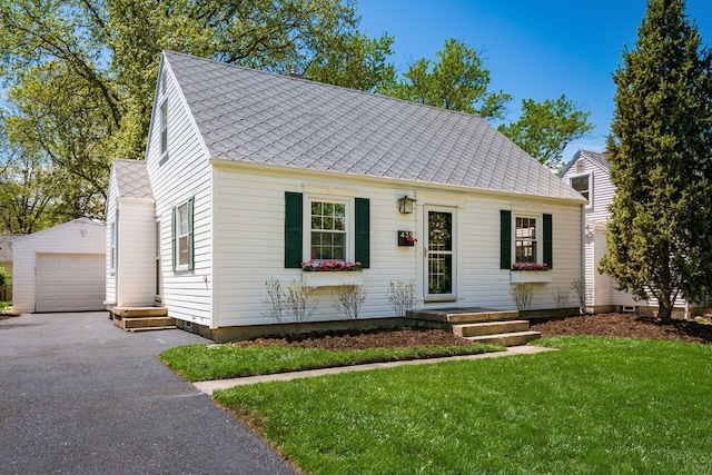 439 Chatham Rd, Columbus, OH 43214 - view of front of house featuring roof with shingles, an outdoor structure, aphalt driveway, a garage, and a front yard