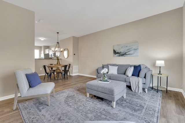 483 Autumn Ridge Cir, Pickerington, OH 43147 - living room featuring wood finished floors, baseboards, and a chandelier