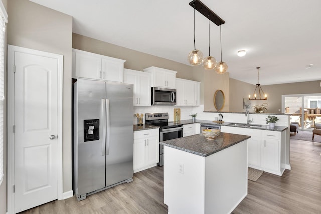 483 Autumn Ridge Cir, Pickerington, OH 43147 - kitchen with appliances with stainless steel finishes, a sink, a peninsula, and light wood-style floors