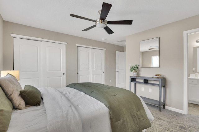 483 Autumn Ridge Cir, Pickerington, OH 43147 - bedroom featuring multiple closets, ensuite bathroom, baseboards, light colored carpet, and ceiling fan