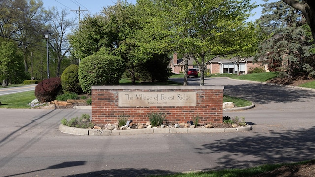 community sign featuring curved driveway