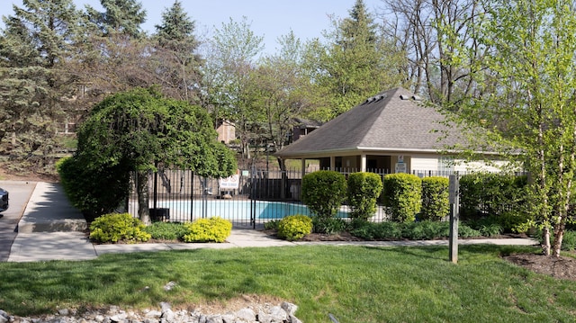 surrounding community with a swimming pool, fence, and a yard