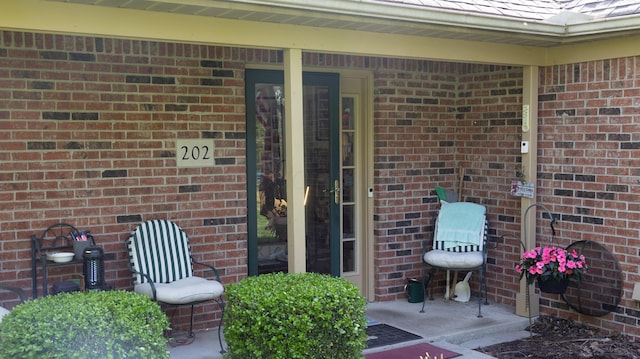 entrance to property featuring brick siding