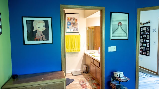 bathroom featuring baseboards, wood finished floors, and vanity