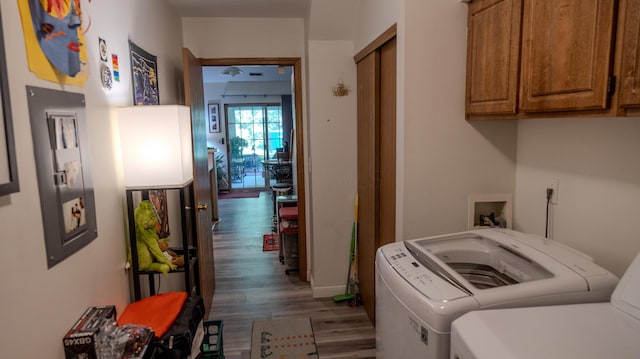 laundry room with baseboards, independent washer and dryer, cabinet space, and wood finished floors