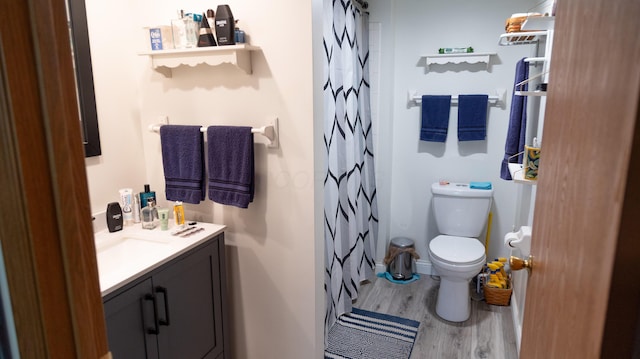 full bath with vanity, wood finished floors, toilet, and a shower with curtain
