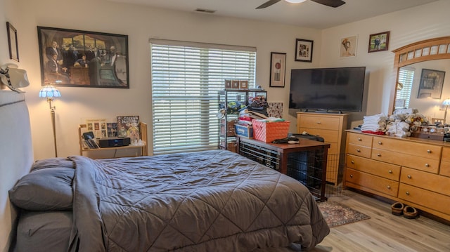bedroom featuring ceiling fan, wood finished floors, and visible vents