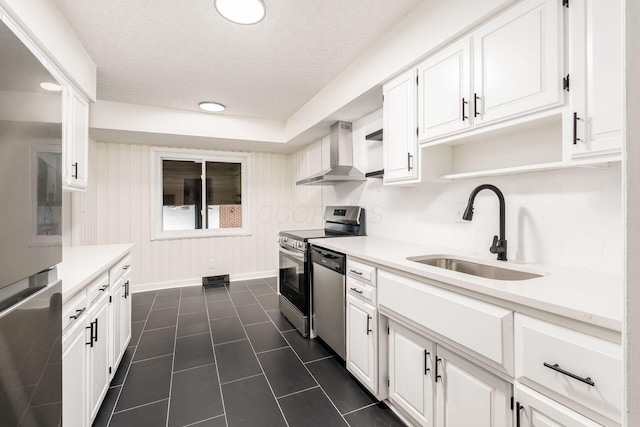 2583 Kingston Ave, Grove City, OH 43123 - kitchen with a textured ceiling, appliances with stainless steel finishes, white cabinetry, a sink, and wall chimney exhaust hood