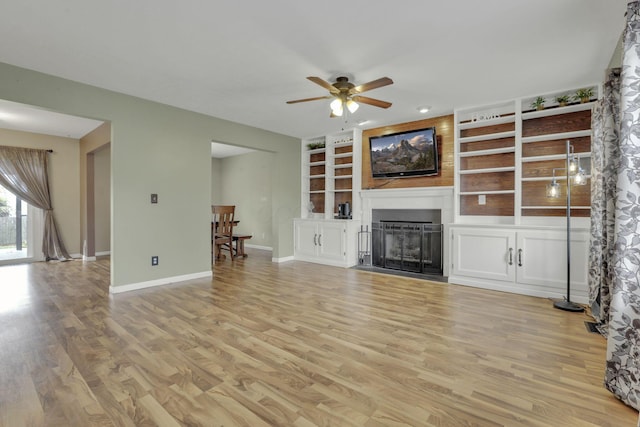 347 Wyncroft Ct, Pataskala, OH 43062 - unfurnished living room featuring ceiling fan, light wood finished floors, a fireplace, built in shelves, and baseboards