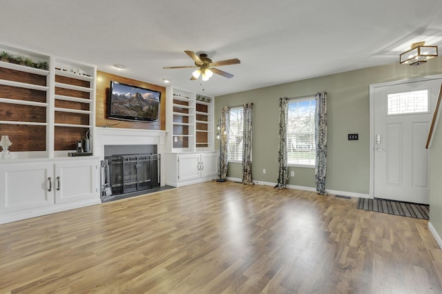 347 Wyncroft Ct, Pataskala, OH 43062 - unfurnished living room featuring baseboards, a ceiling fan, light wood-style floors, and built in shelves