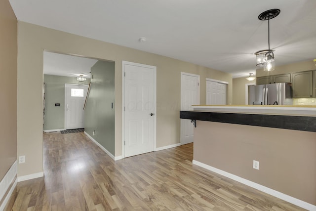 347 Wyncroft Ct, Pataskala, OH 43062 - kitchen with light wood-type flooring, freestanding refrigerator, baseboards, and decorative light fixtures