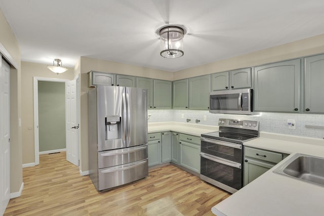 347 Wyncroft Ct, Pataskala, OH 43062 - kitchen featuring decorative backsplash, appliances with stainless steel finishes, a sink, light countertops, and light wood-style flooring