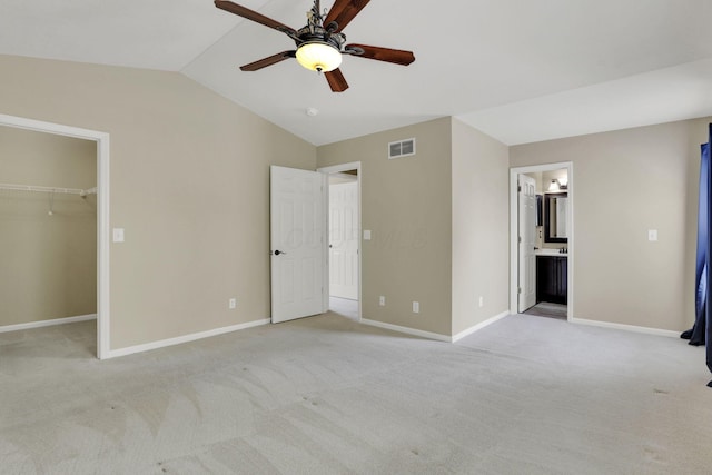347 Wyncroft Ct, Pataskala, OH 43062 - unfurnished bedroom with light colored carpet, visible vents, a walk in closet, and vaulted ceiling