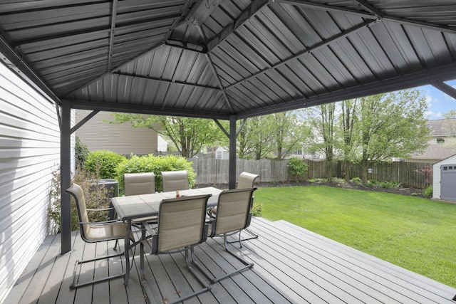 347 Wyncroft Ct, Pataskala, OH 43062 - wooden deck with an outdoor structure, outdoor dining area, a fenced backyard, a storage unit, and a lawn