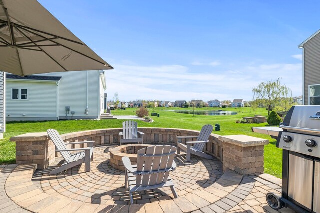 view of patio with a water view, an outdoor fire pit, and area for grilling