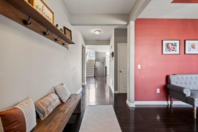 hallway with baseboards, dark wood-style flooring, and stairway