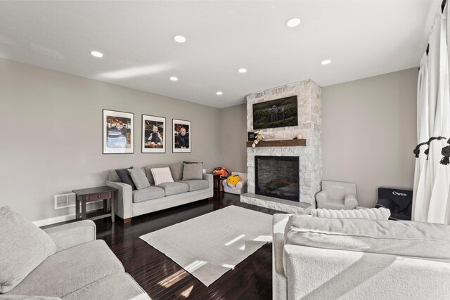 living room featuring visible vents, a fireplace, recessed lighting, and dark wood-type flooring