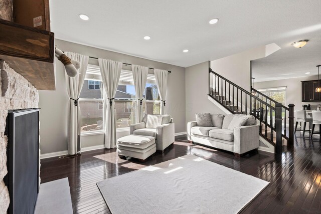 living room with hardwood / wood-style flooring, baseboards, and stairway
