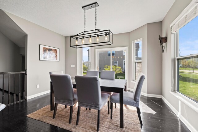 dining room featuring dark wood-style flooring, baseboards, and a wealth of natural light