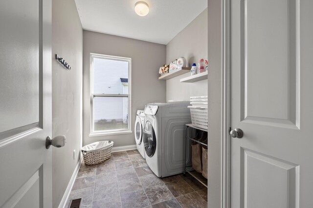 laundry room with laundry area, separate washer and dryer, baseboards, stone finish flooring, and visible vents