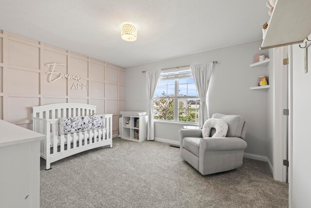 bedroom featuring carpet floors, baseboards, visible vents, and a crib