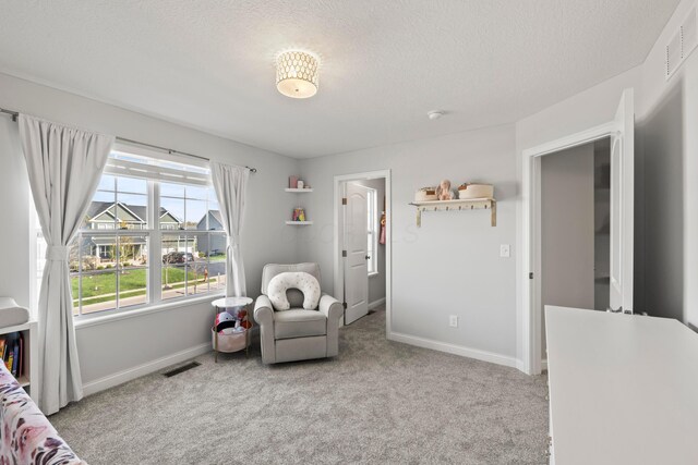 carpeted bedroom featuring a textured ceiling, baseboards, and visible vents