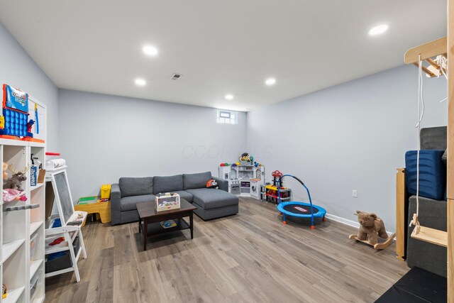 living room with visible vents, recessed lighting, baseboards, and wood finished floors