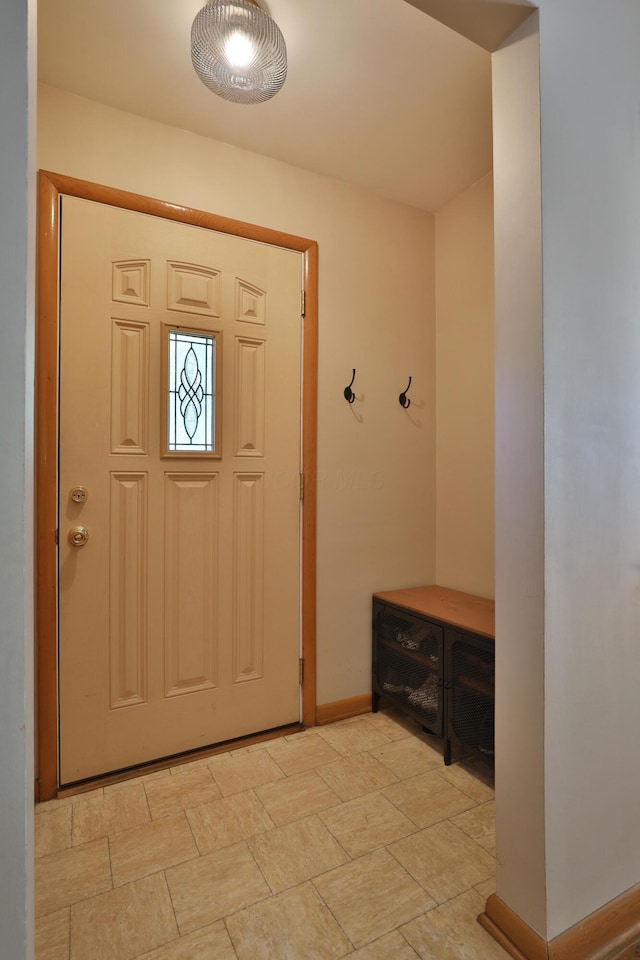 entrance foyer featuring baseboards and stone finish flooring