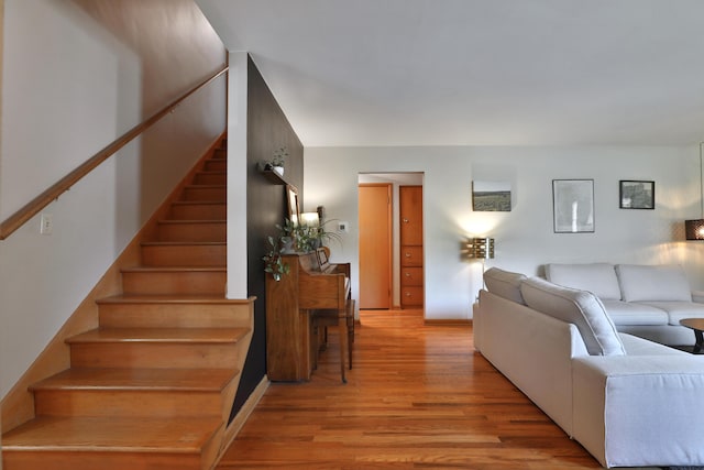 living area featuring light wood-style flooring and stairway