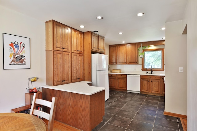 kitchen featuring recessed lighting, brown cabinets, white appliances, and dark tile patterned flooring