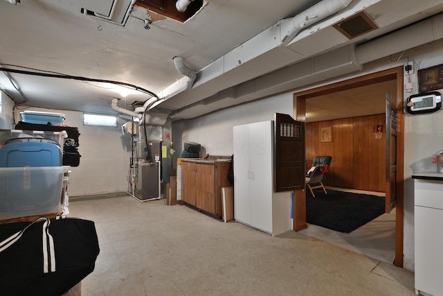basement with heating unit, light floors, and visible vents