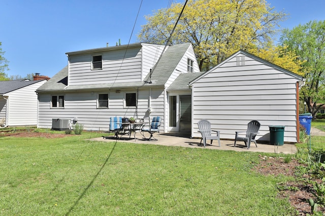 rear view of property featuring a lawn, central AC unit, a patio area, and a shingled roof